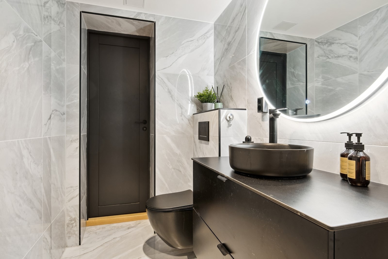 Rommet er innredet med dusjnisje, moderne servant med underskuffer i lekker innredning, veggmontert toalett med skjult sisterne , samt opplegg for vaskemaskin. Galleribilde