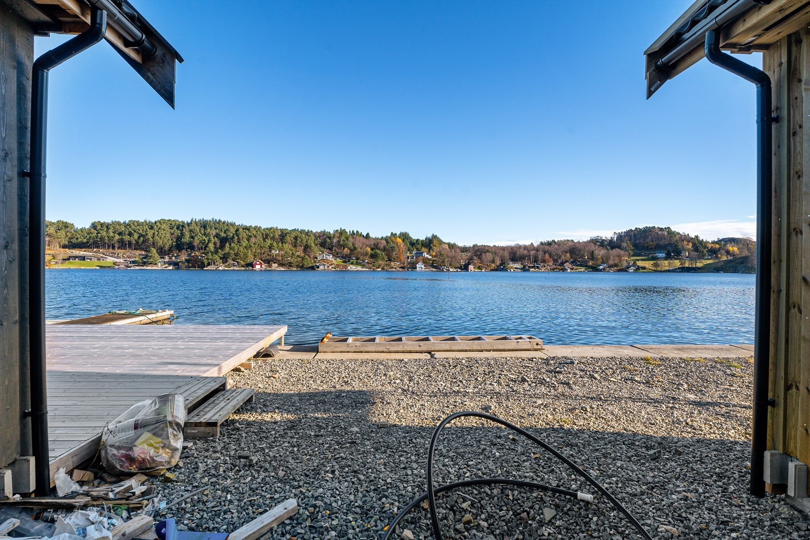 Byggeklar nausttomt som er planert, trekkrør/rør lagt klar for vann/avløp og med solid kai i betongblokker Galleribilde