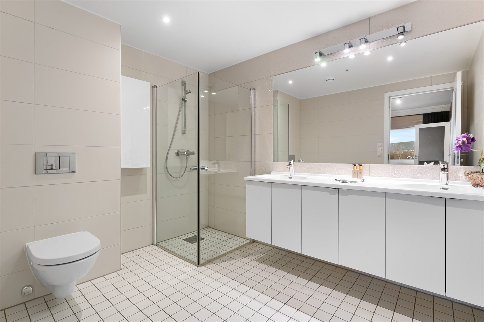 Badet er også av god størrelse med dobbelt servant og mye skapplass. Dusjhjørne og vegghengt toalett. Galleribilde