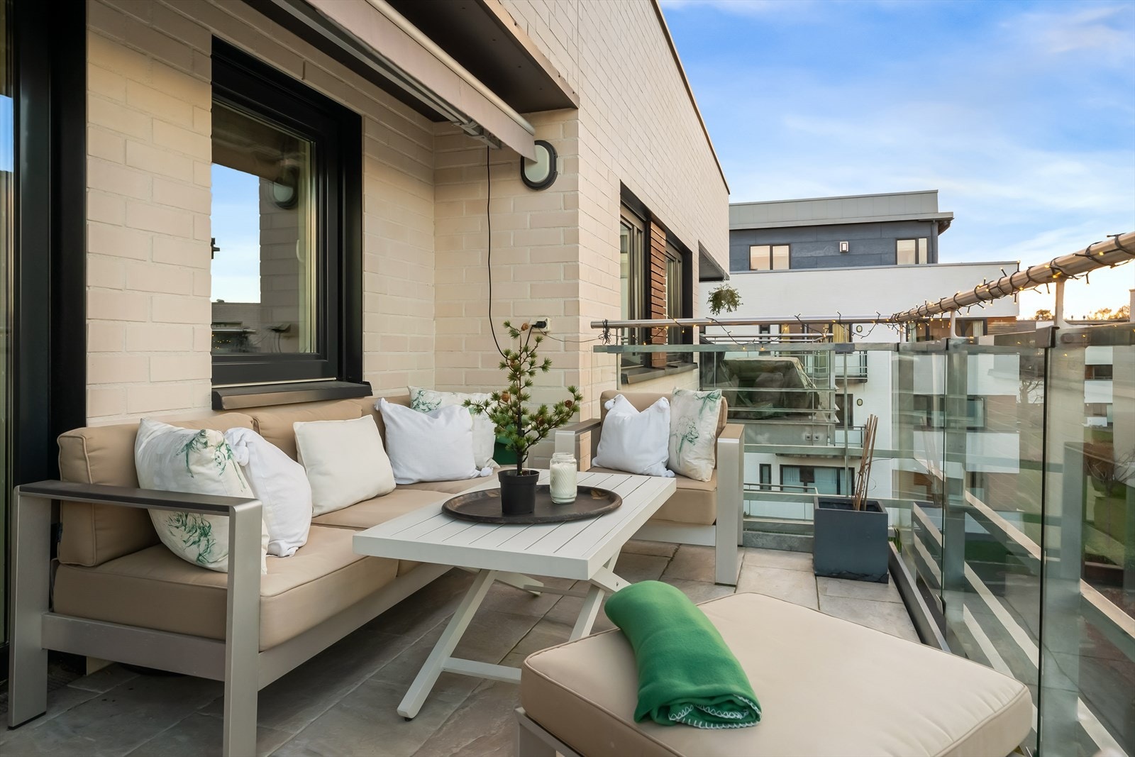 Balkongen er på hele 11 kvm. Her er det markise for varme sommerdager, stikkontakt og fliser på gulvet. Galleribilde