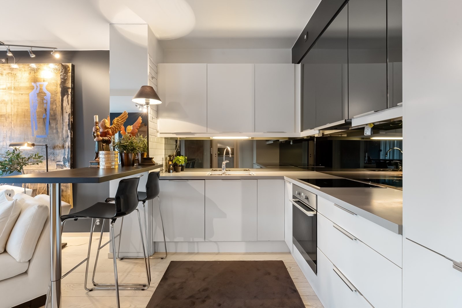 Kjøkkenet har innredning med glatte- og speilfronter. Speil over benkeplatene gir ekstra god romfølelse. Galleribilde