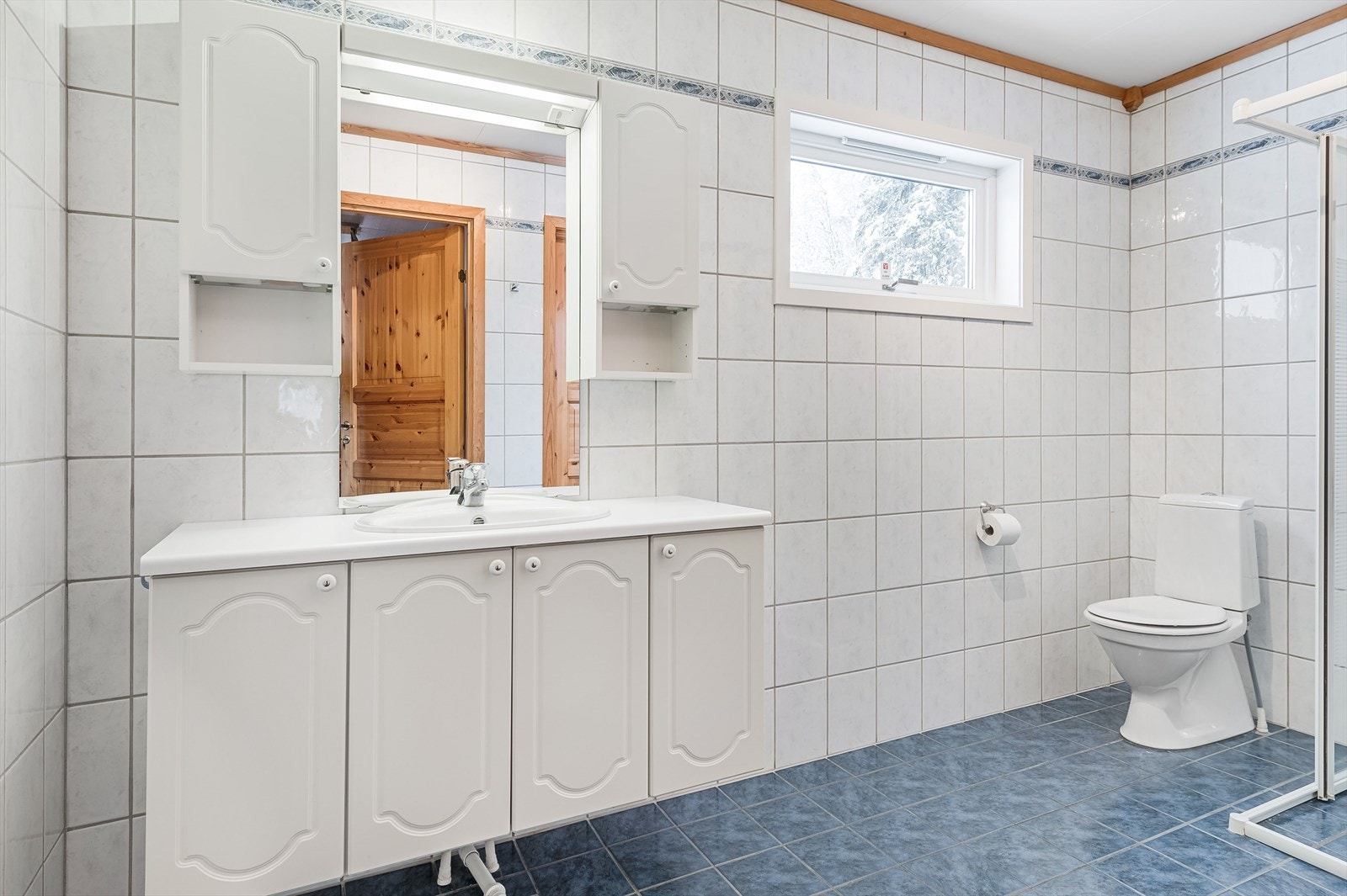 Badet har innredning med servant, toalett og dusjhjørne Galleribilde