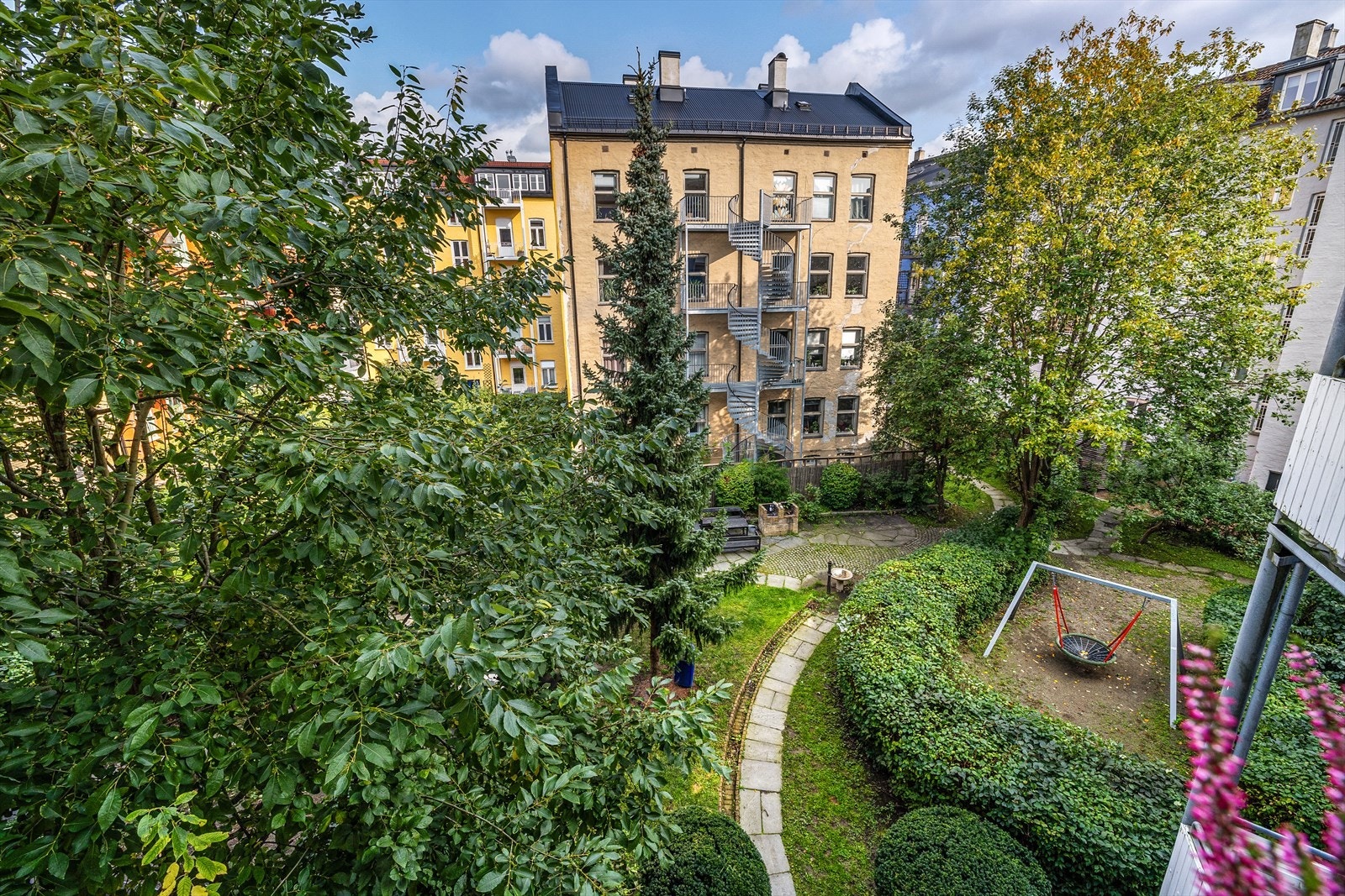 - Den frodige bakgården har flere skjermede soner og lekeapparater - Galleribilde
