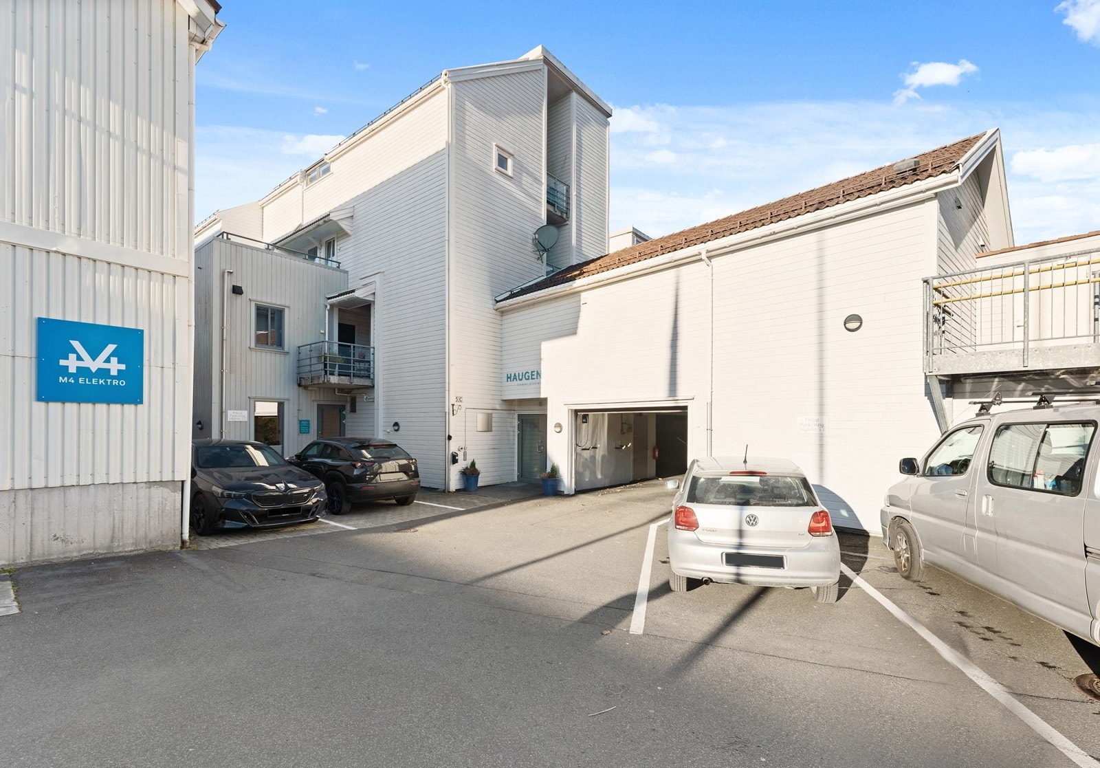 Inngang til leilighetsbygget og gjesteparkeringer. Galleribilde