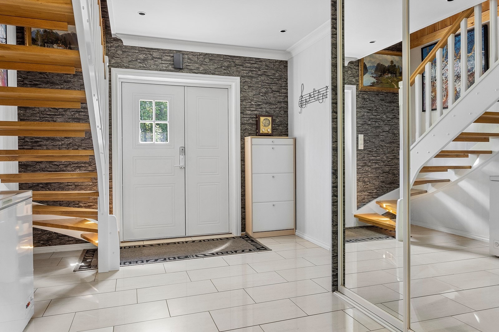 Innenfor døren finner man en romslig hall med plass til garderobeløsning eller kommode. Det er montert stor skyvedørsgarderobe i speil. Galleribilde