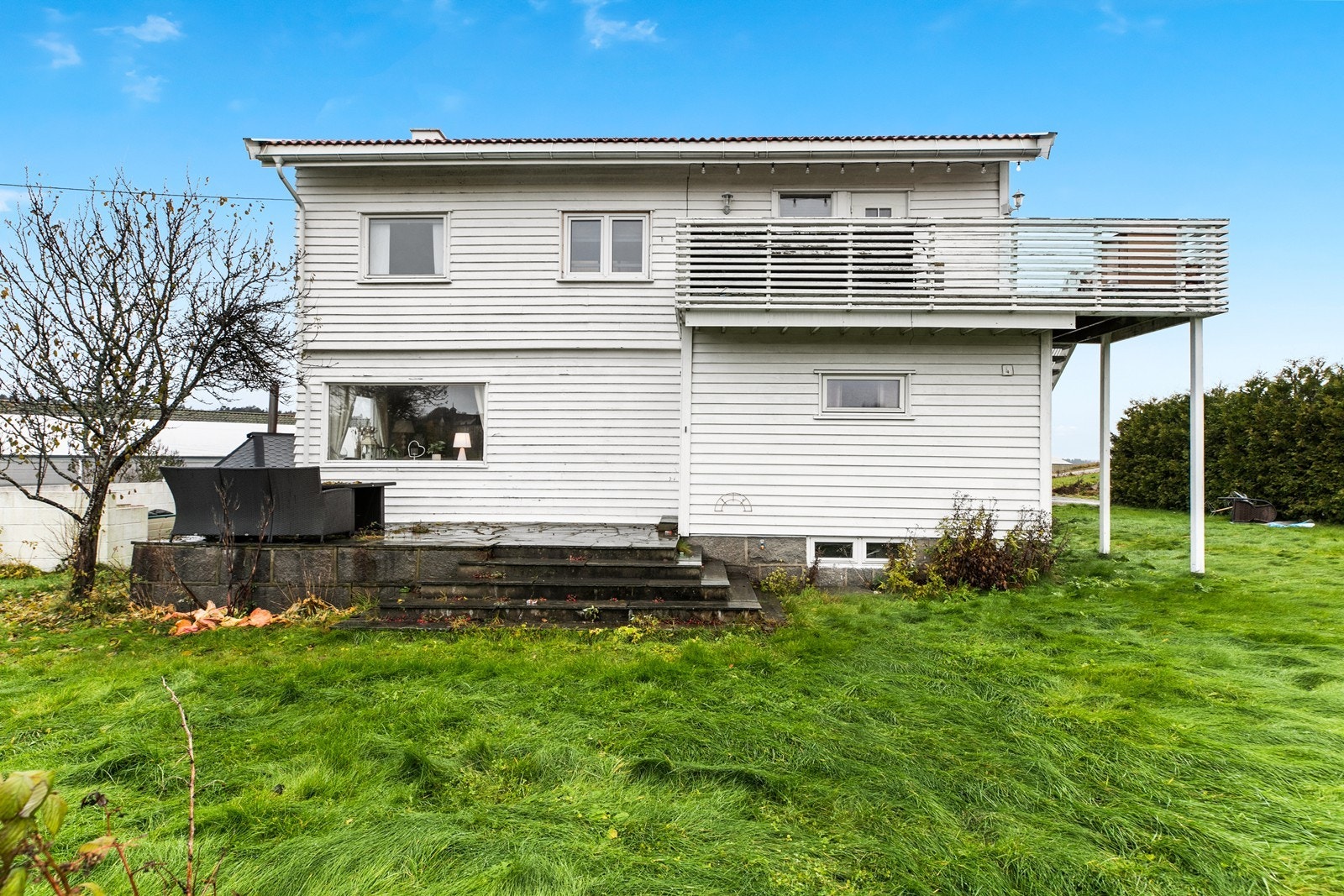 I fra 1. etasje er det utgang til en hellelagt platting, med direkte adkomst til hageområdet - og i 2. etasje er det en veranda i forbindelse med inngangspartiet Galleribilde