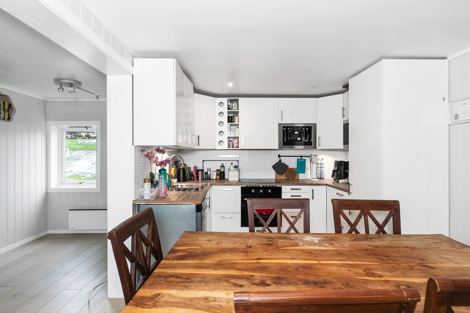 Kjøkkeninnredningen ble satt inn av en tidligere eier, og har slette fronter og laminerte benkeplater. Det er integrert koketopp, stekeovn,
mikrobølgeovn, kaffemaskin og kjøl- og fryseskap Galleribilde