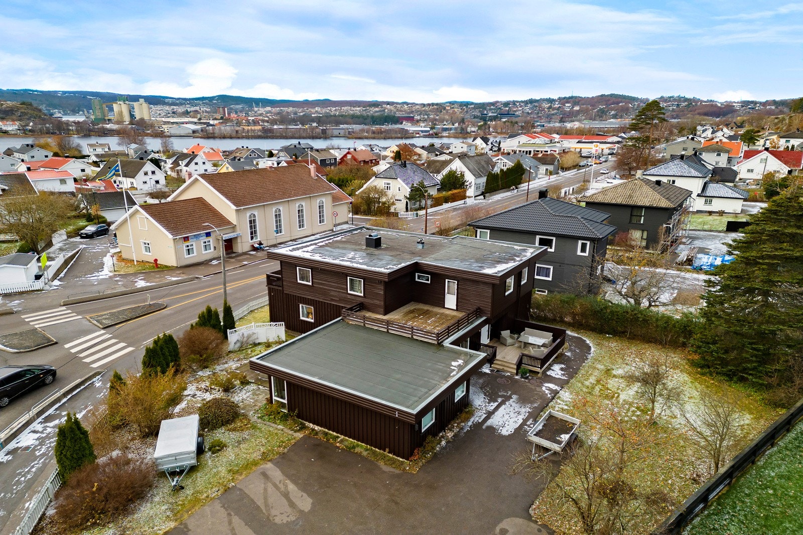 Hjørnetomten har asfaltert gårdsplass med parkering og fin hage med plen og gode solforhold. Galleribilde