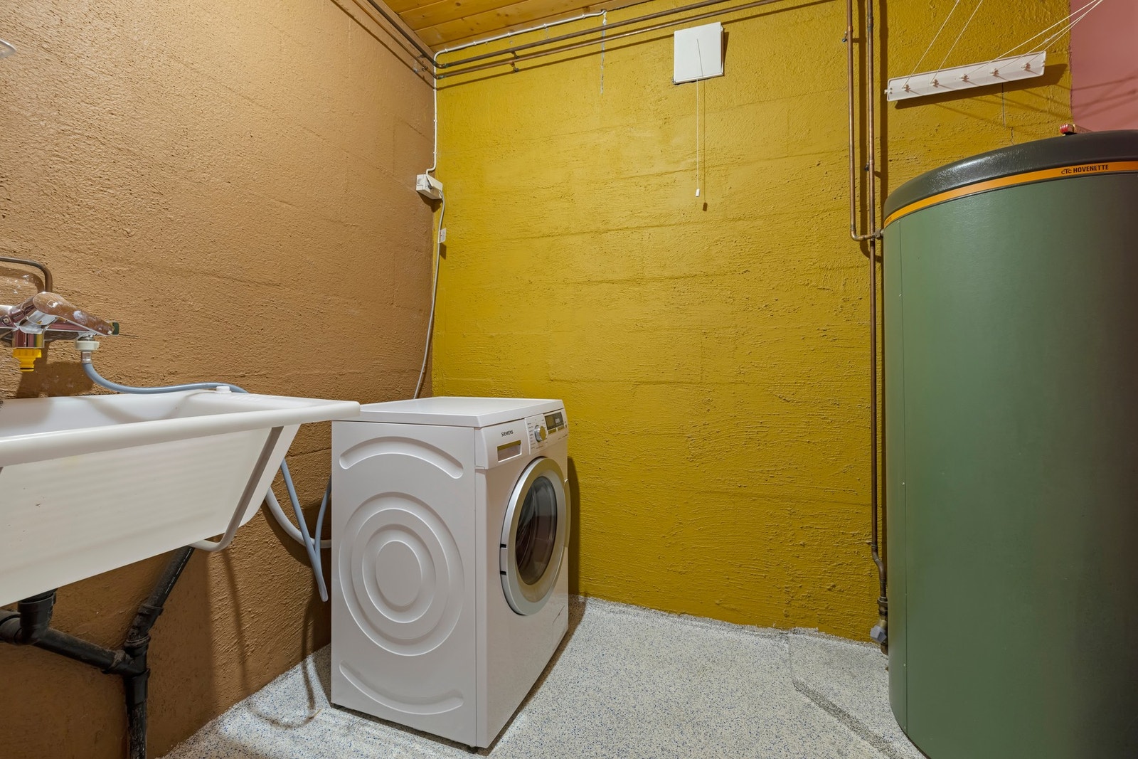 Vaskerom i kjeller epoxybelegg med gulvvarme, vegghengt skyllekar i plast. Opplegg for vaskemaskin Galleribilde