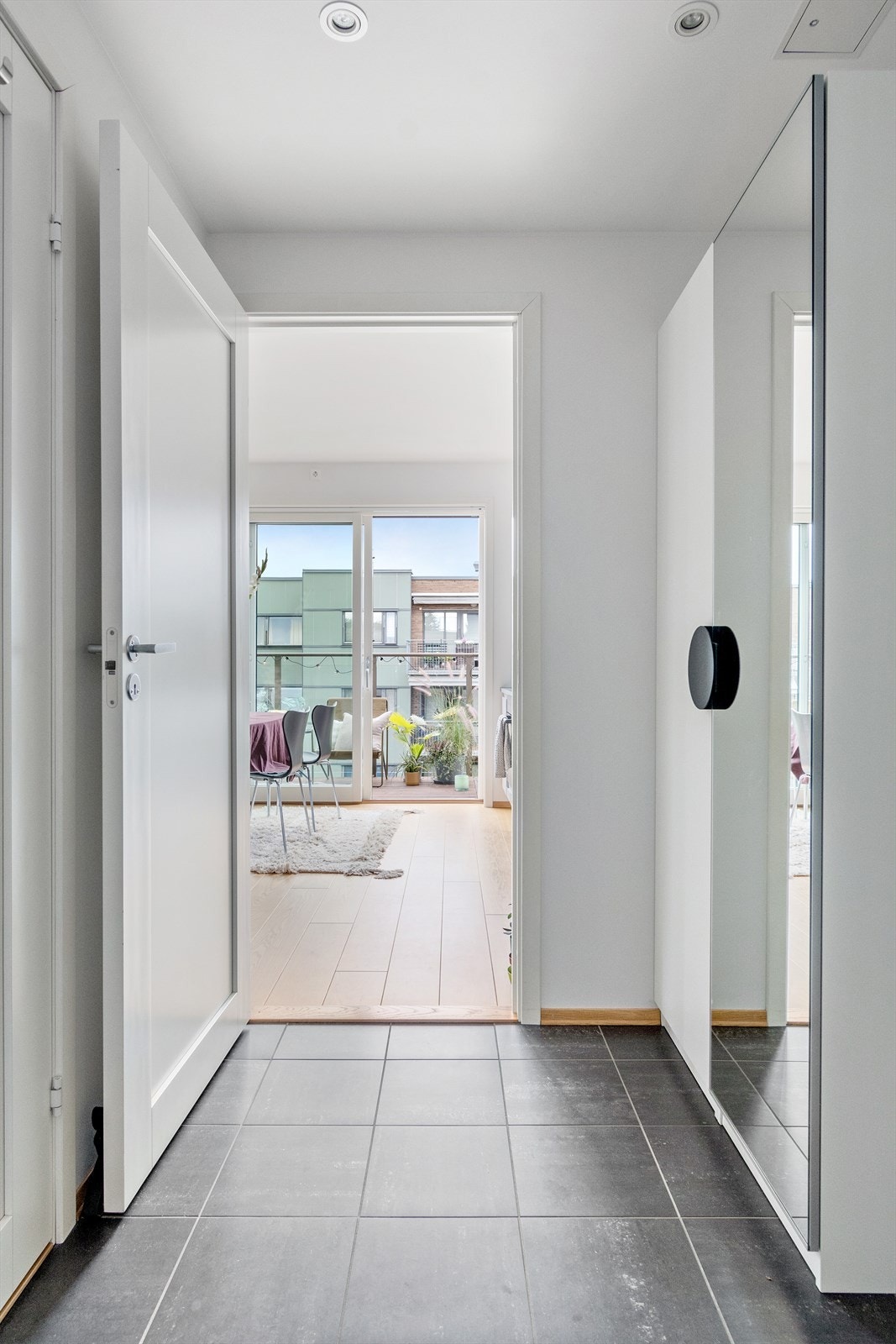 Innbyende entré med praktisk flislagt gulv, downlights i taket og lysmalte vegger Galleribilde