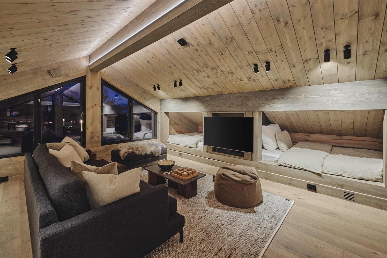 Med sofa, saccosekker og tv er dette plassen for den perfekte filmkvelden. Gjennom store vindu mot øst ser en rett i skibakken ved gondolen. Galleribilde