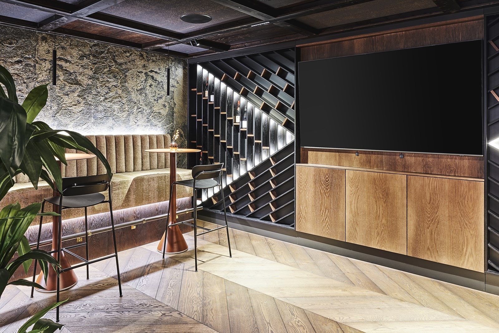 Sittegruppen mot vest består av en spesiallaget vegghengt sittebenk trekt med tekstil og innfelt ledstripe i toppen, mot en bakvegg i steinfiner, samt barbord og barstoler. Galleribilde