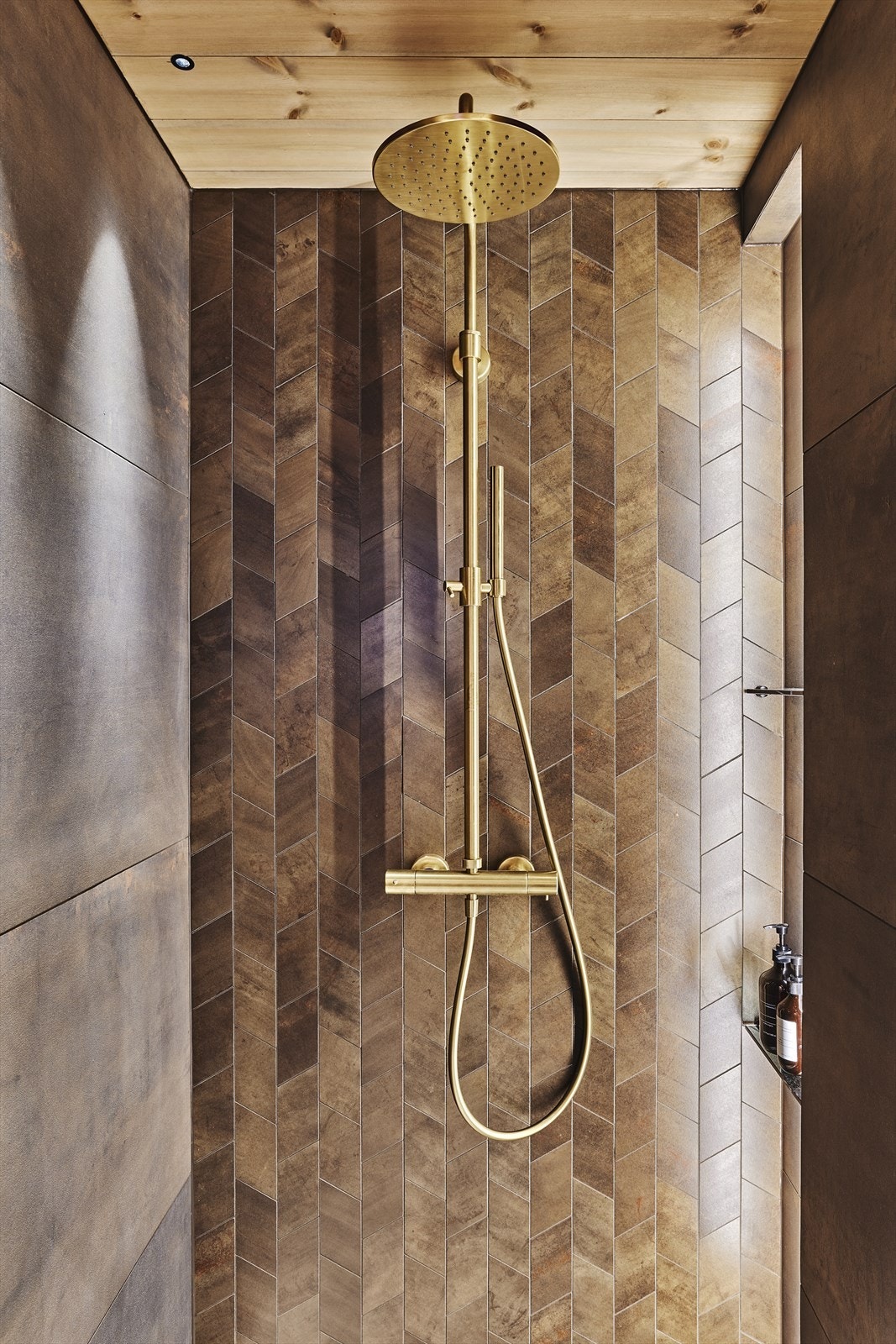 Videre er det dusjarmatur/takdusj i børsta gull fra spillo up og sort toalett. Galleribilde