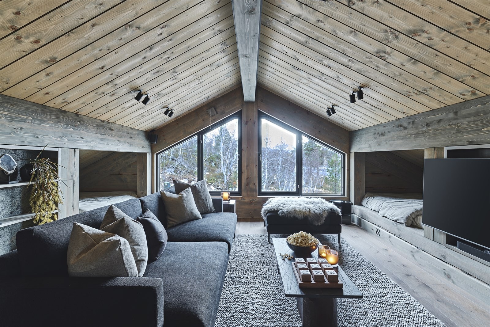 I tv-stuen i denne etasjen er det innebygd 4 store daybeds/senger med stofftrekte skillevegger og innfelte nisjer med lademuligheter og leselys. Galleribilde