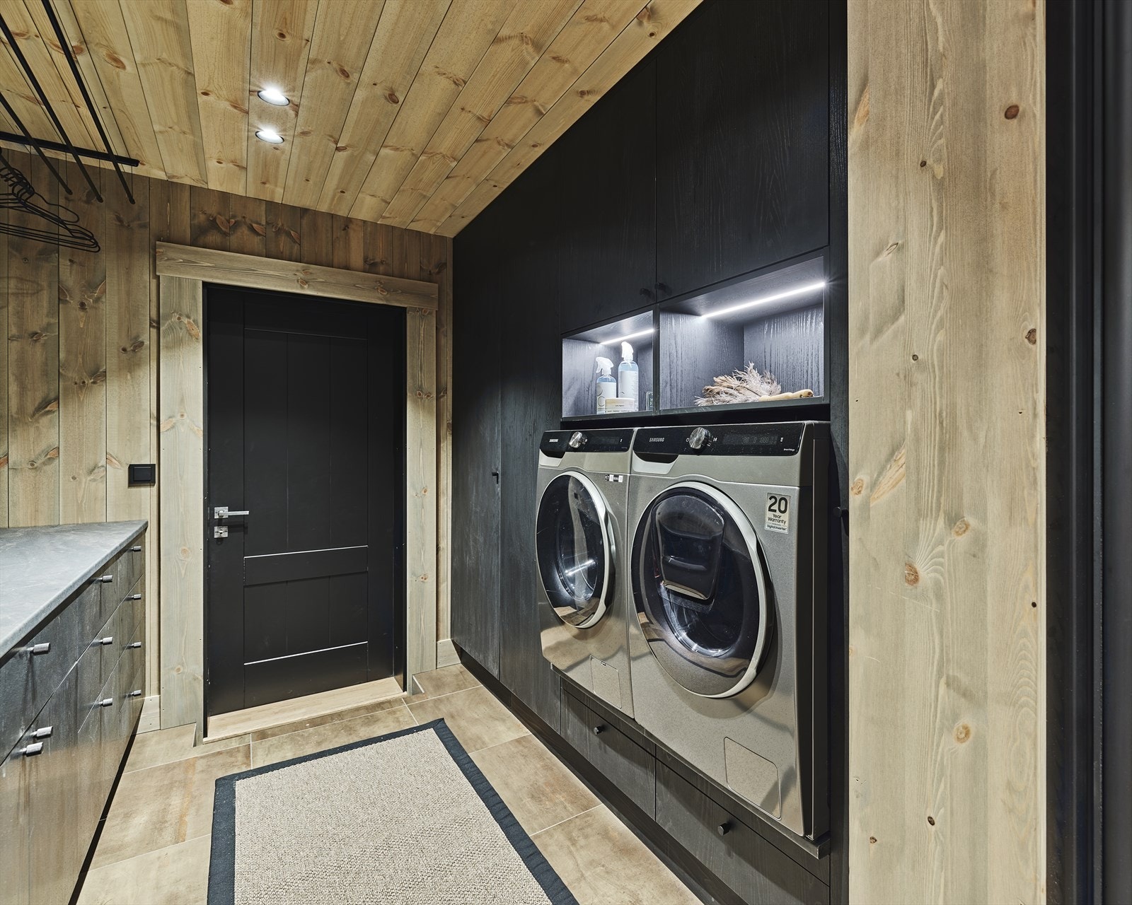 Kjelleretasjen har også et stort vaskerom med inngang fra garasje og fra oppholdsrom. Vaskerommet er utstyrt med vaskemaskin og kombi vask/tørk fra Samsung, spesiallaget skap for tørking og oppheng i tak for tørking av klær. Galleribilde