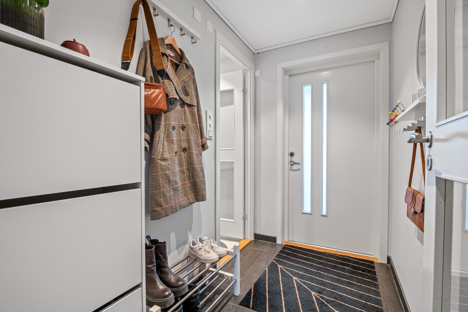 Velkommen inn! Lys og romslig entré med plass til å henge fra seg klær og sko. Galleribilde