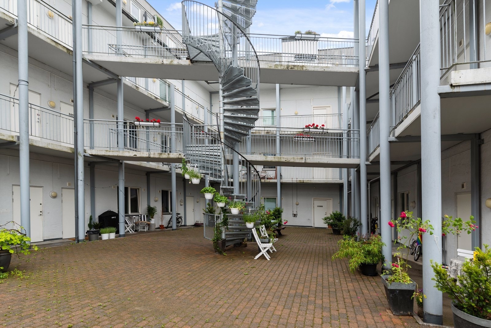 Bakgården er pent beplantet og det er satt ut bord til felles bruk Galleribilde