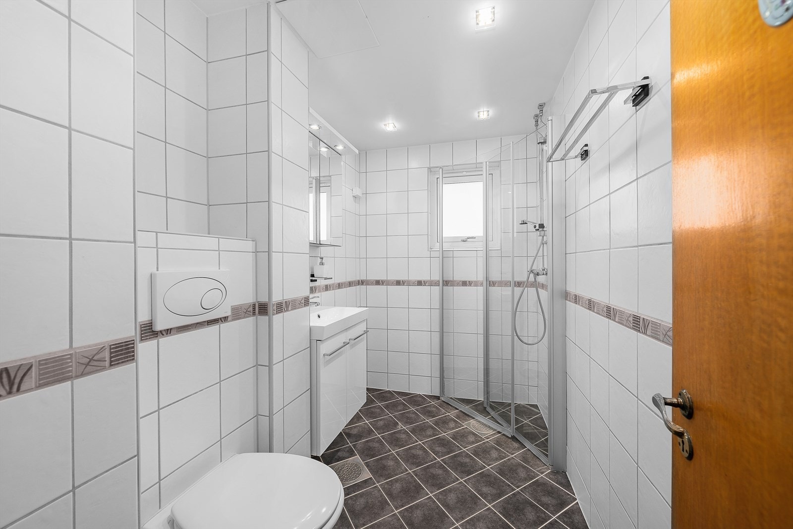 Badet ble pusset opp i regi av borettslaget i 2010 og har et pent uttrykk der mørke gulvfliser kombineres med hvite fliser på veggene. Galleribilde