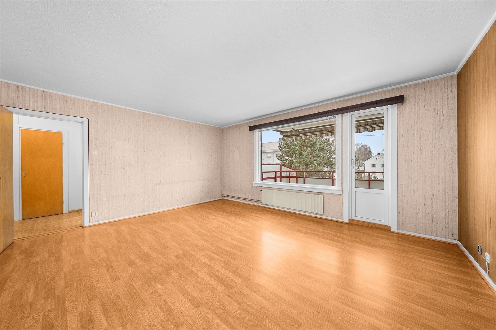 Stuen innredes enkelt i ulike soner - uten at det oppleves rotete. På gulvet er det lagt laminat, mens veggene er kledd med lys strie og tapet som ligner panel. Galleribilde