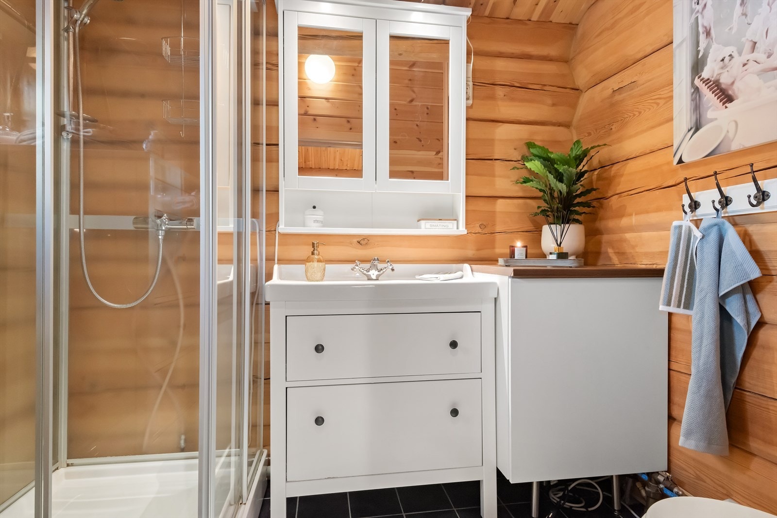 Badet er innredet med fliser på gulv og panel/tømmer på vegger, og er utstyrt med baderomsinnredning, dusjkabinett og toalett med kvern. Her kan du glede deg over elektriske varmekabler i gulvet! Galleribilde