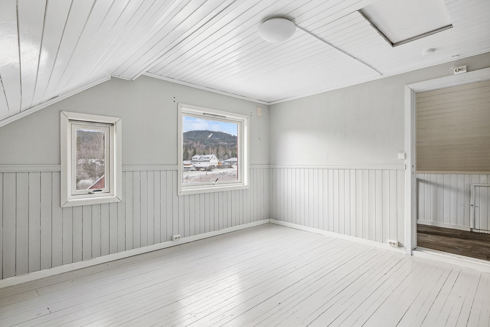 Dette soverommet har malte tregulv og loftsluke Galleribilde