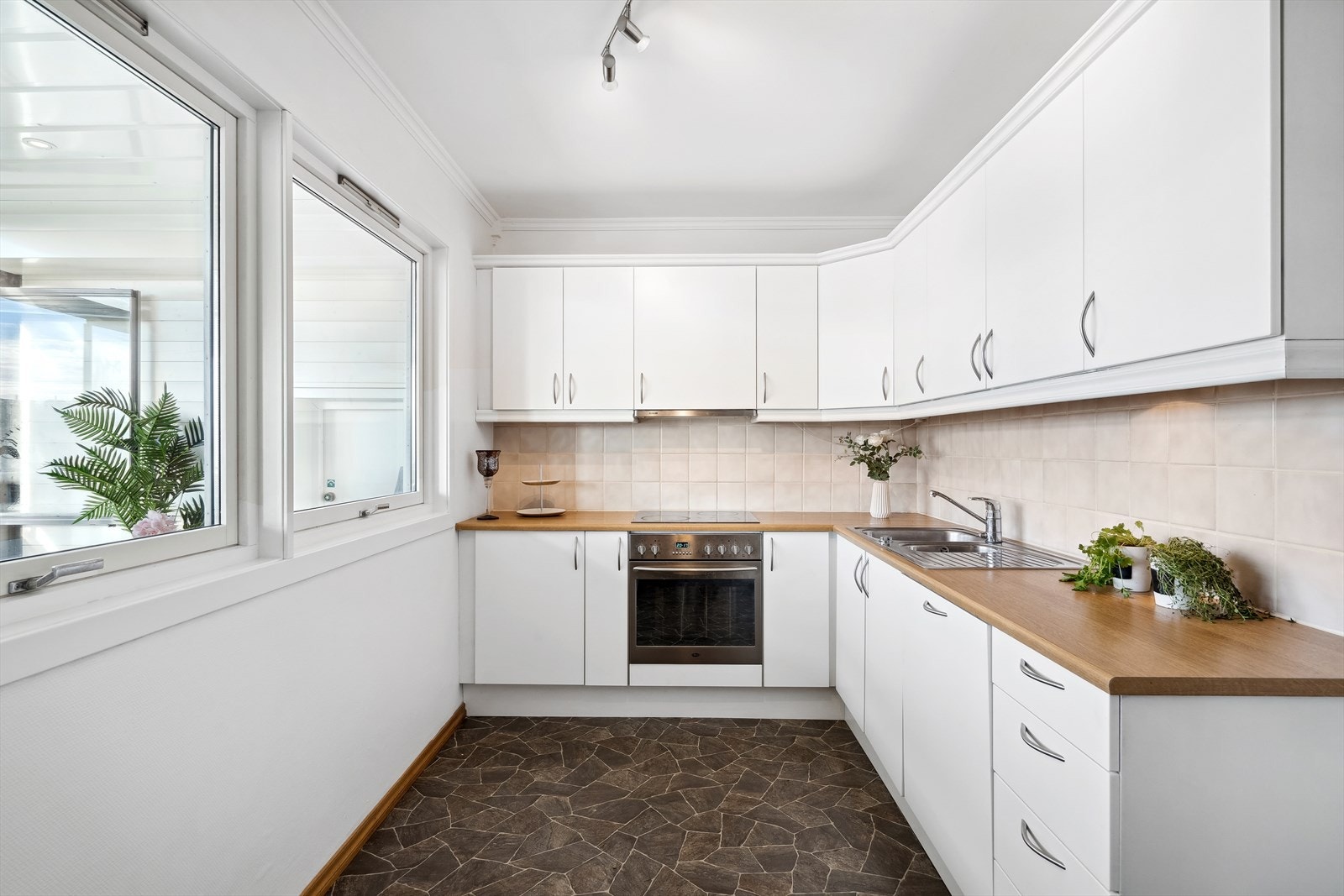 Pent kjøkken med nyere fronter, og en benkeplate av laminat. Galleribilde