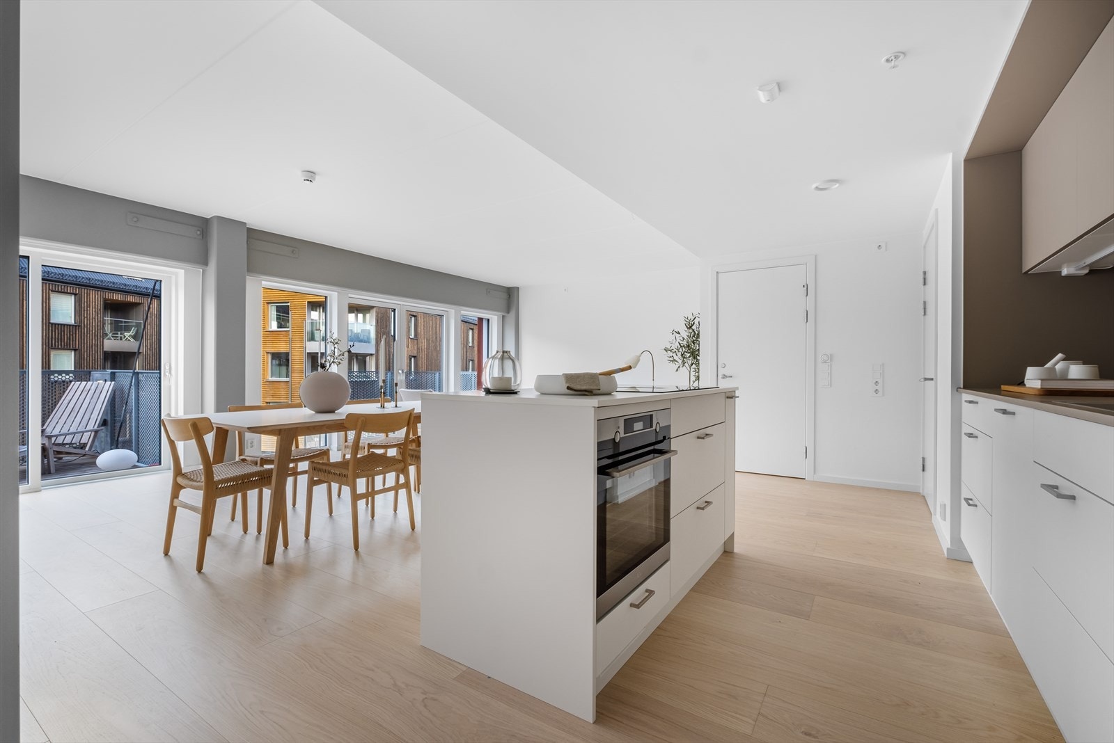 Luftig stue med hyggelig kjøkkenøy med nedfelt induksjon steketopp og avtrekksvifte Galleribilde