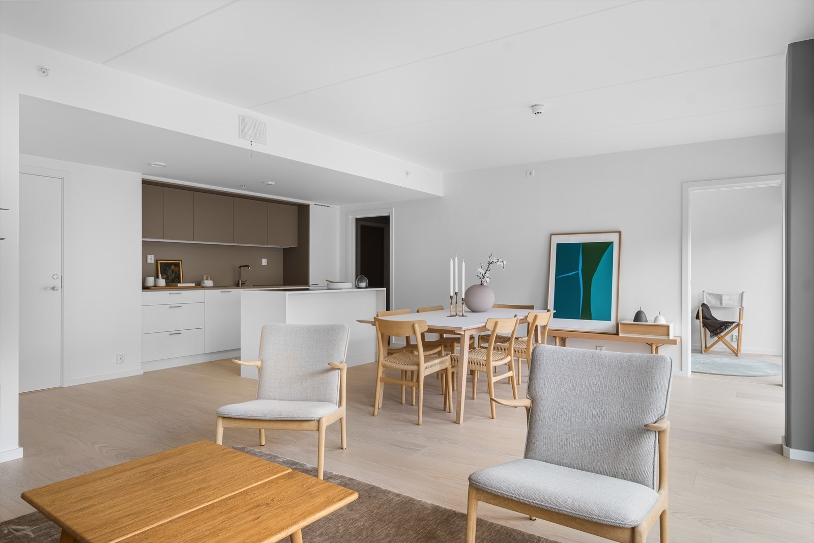 Kjøkkeninnredning faller inn i veggliv og mer markert med beige overskaper, bakvegg og benkeplate. Alle hvitevarer er integrert. Galleribilde