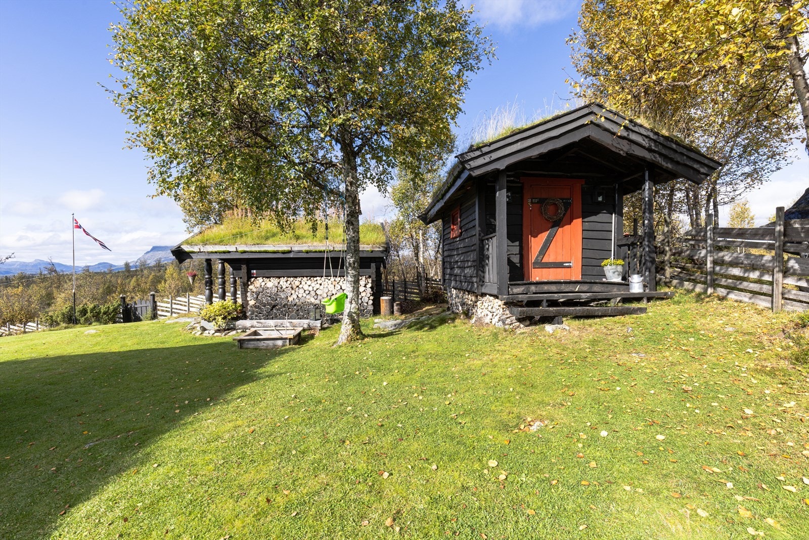 Tomten er pent opparbeidet med plen og beplantning. Galleribilde