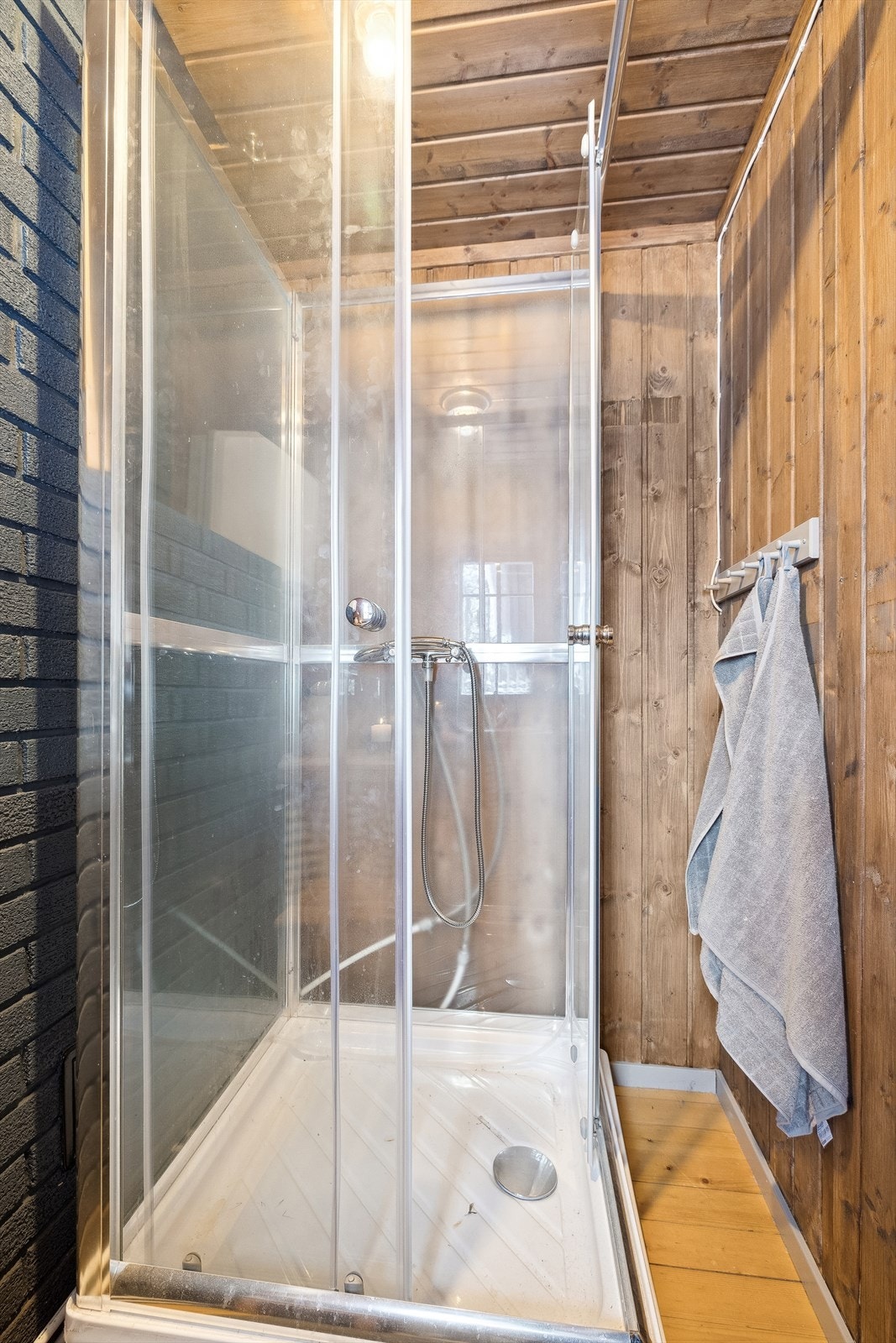 Bad/stellerom er innredet med benk med nedfelt håndvask og dusjkabinett. Innvendige overflater med heltre furugulv og panel på vegger og i himling. Galleribilde