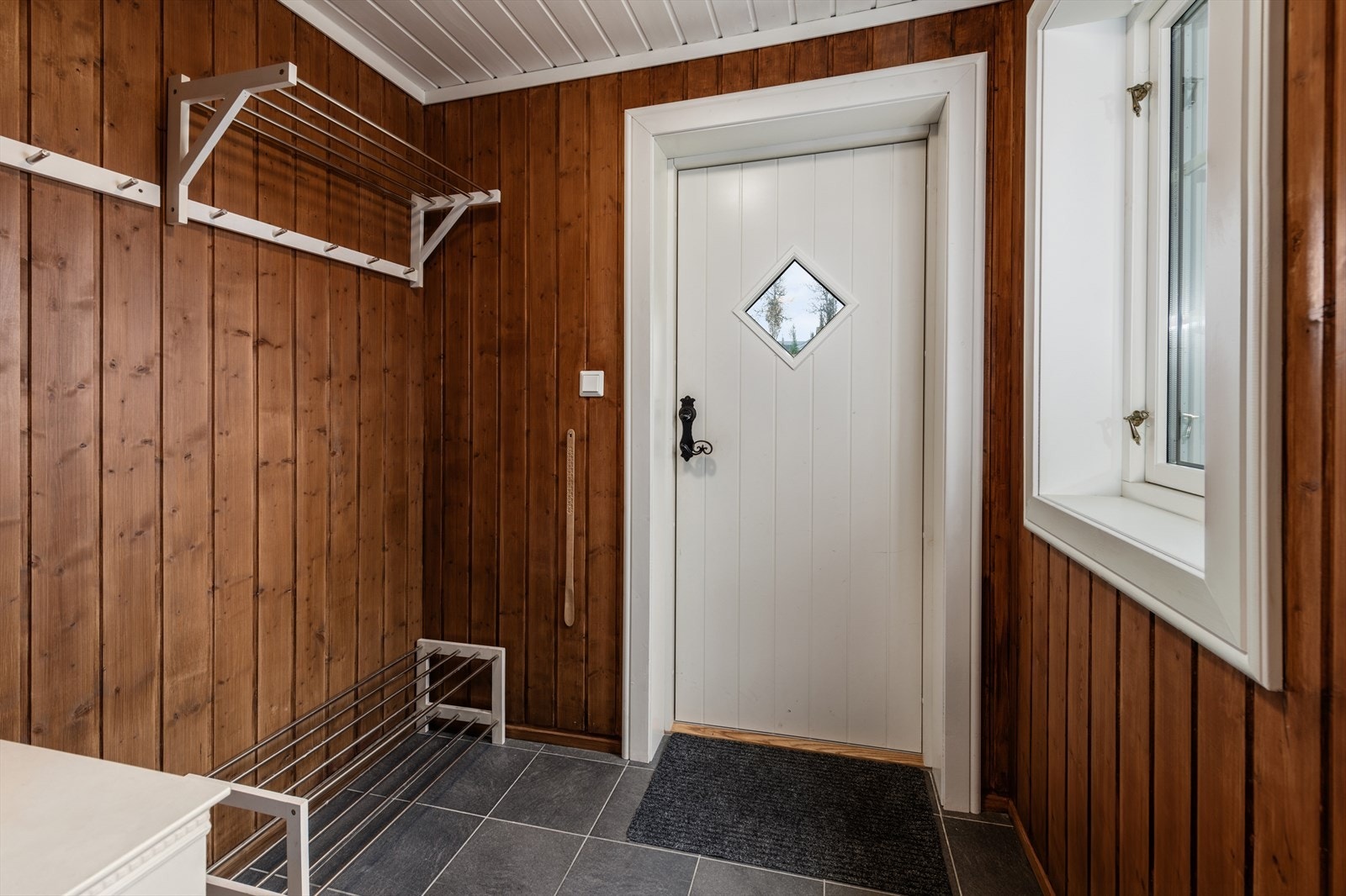 Flislagt entré med varmekabler og god plass til å henge av seg yttertøy. Galleribilde
