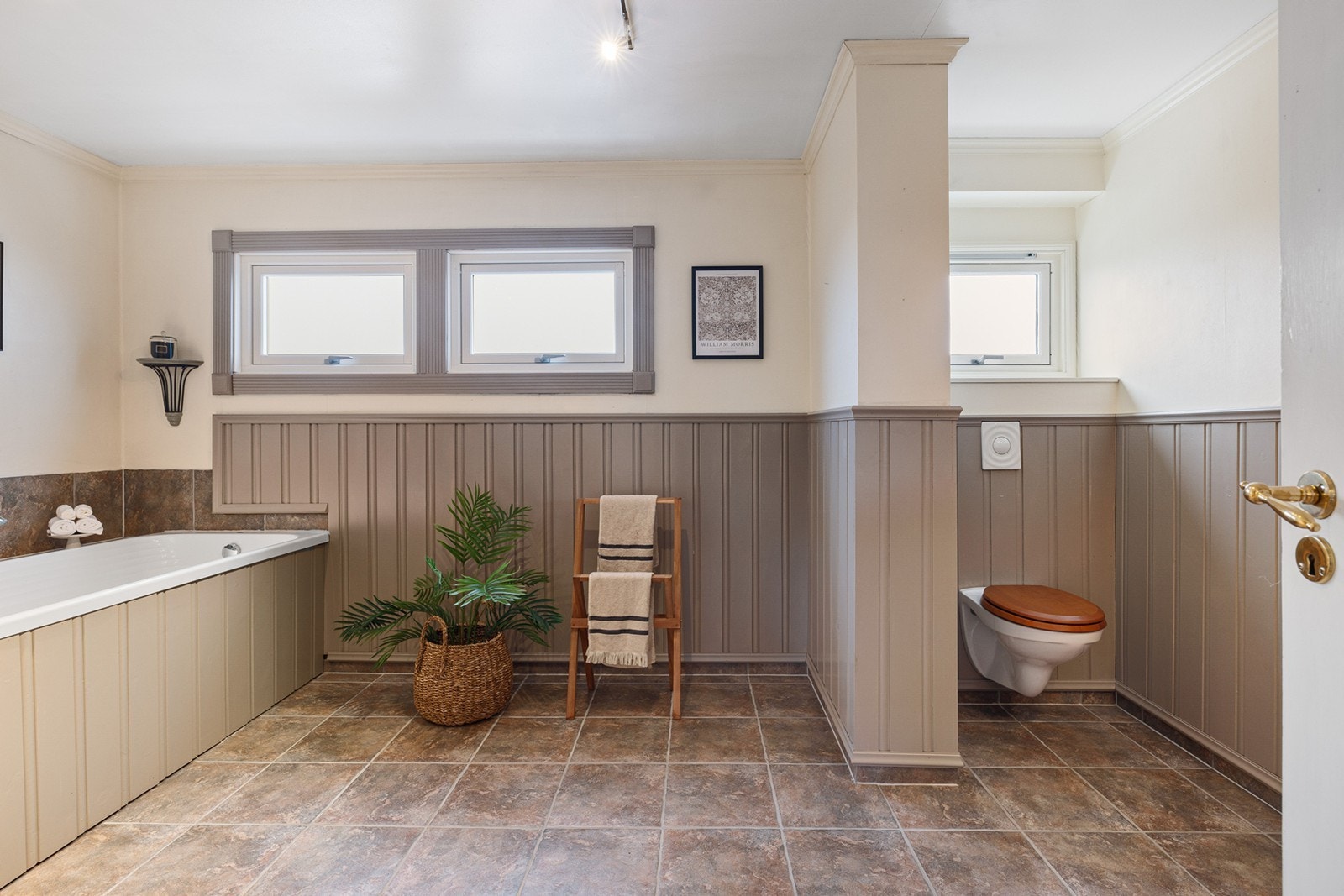 På badet står et innebygd badekar og det er vindu for lufting. Galleribilde