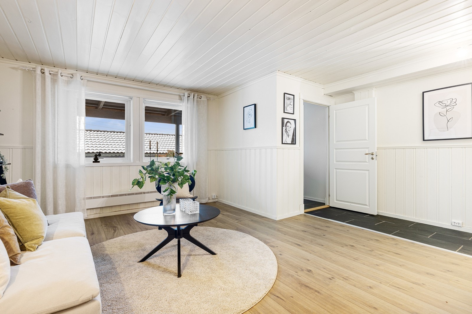 Rommet har store vindusflater, og har lyse veggoverflater med malt panel i himling. Galleribilde