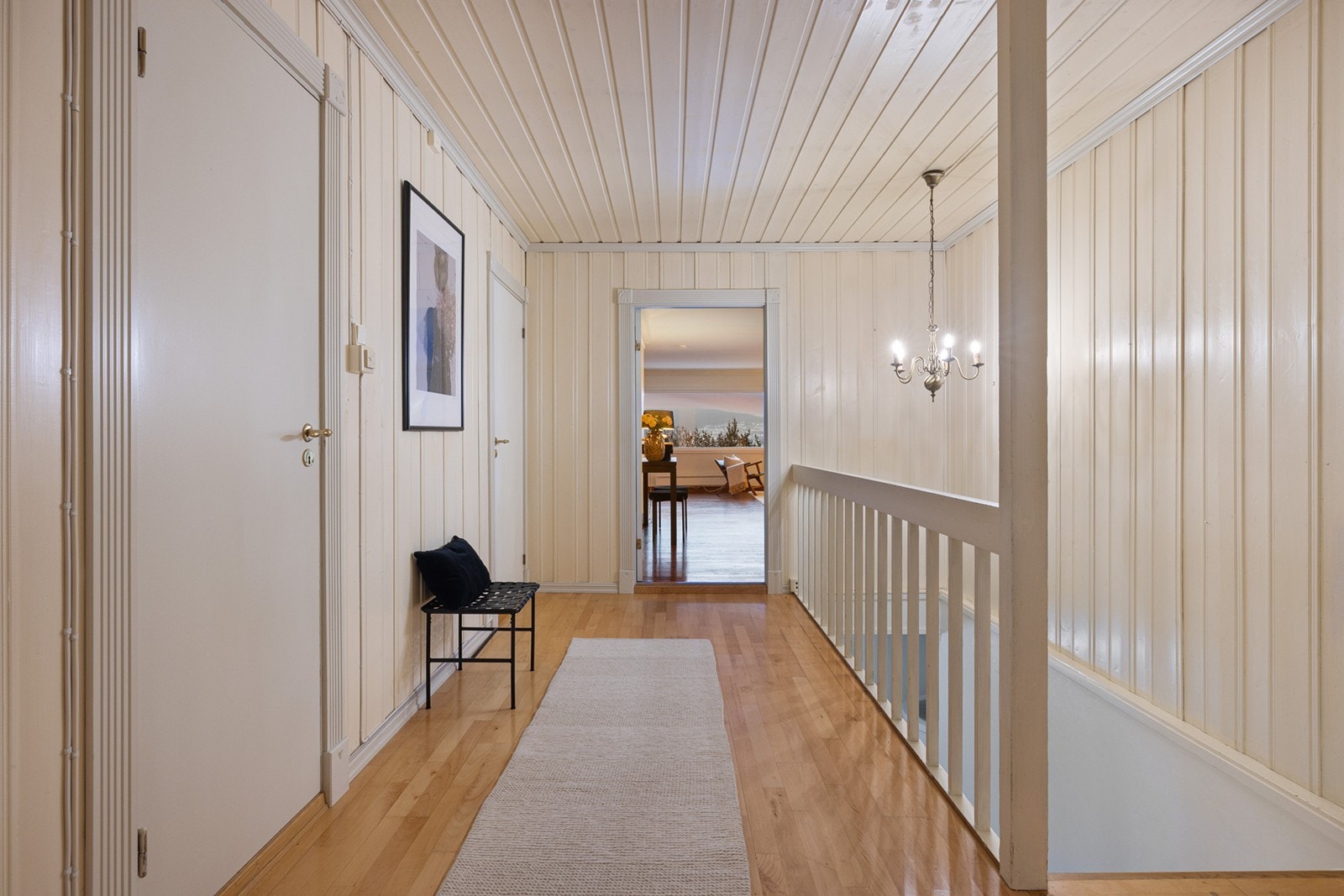 Gang/hall i første etasje er lys og åpen med parkettgulv og malt panel på veggene. Galleribilde