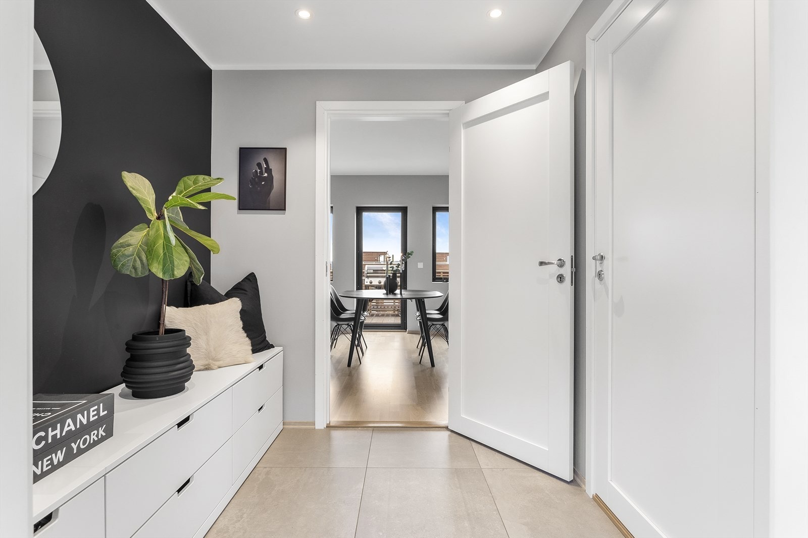 Man ønskes velkommen inn i en lys og romslig gang med downlights i tak, fliser og gulvvarme. Galleribilde