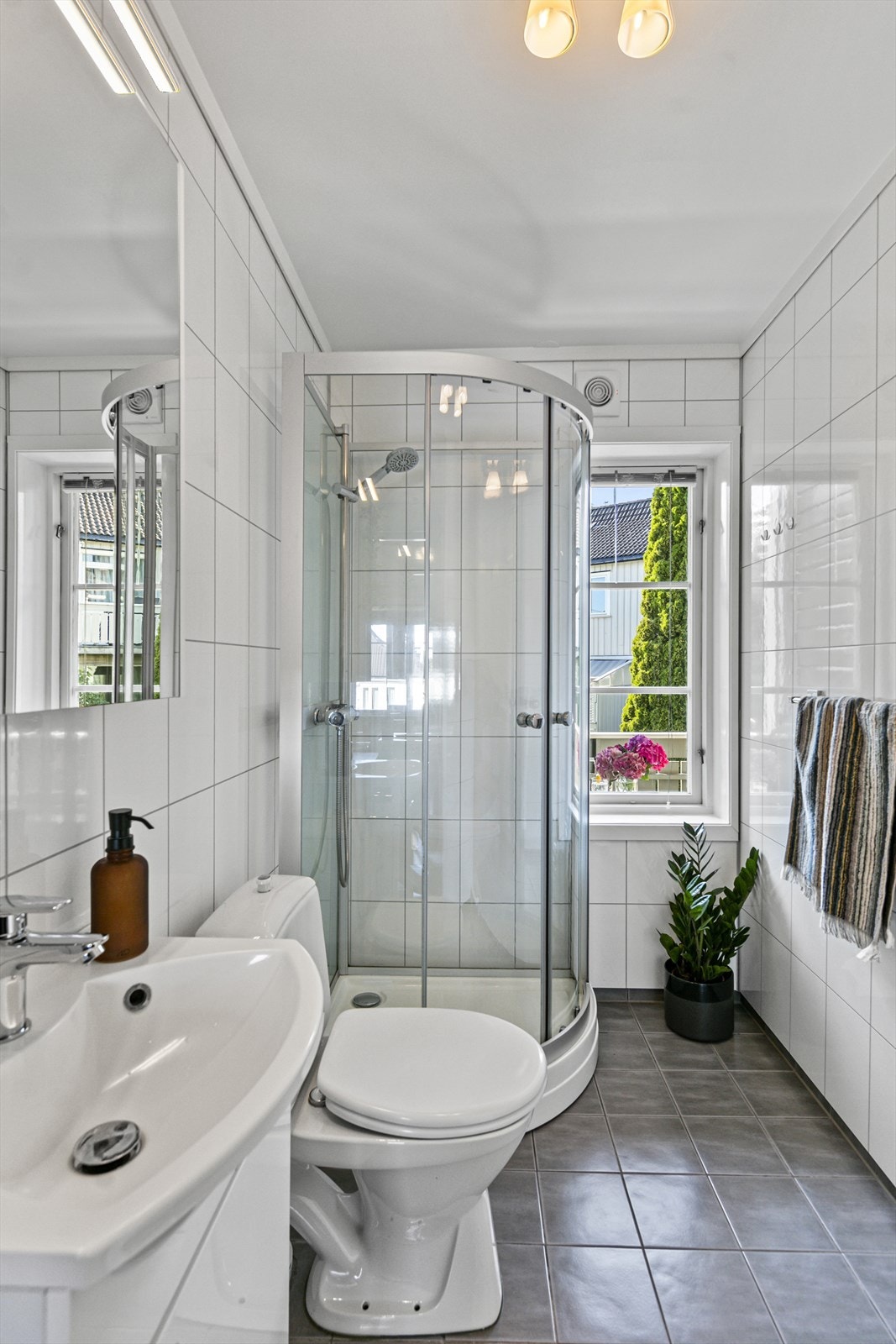 Badet inneholder innredning, servant, wc, opplegg for vaskemaskin og dusjkabinett. Galleribilde