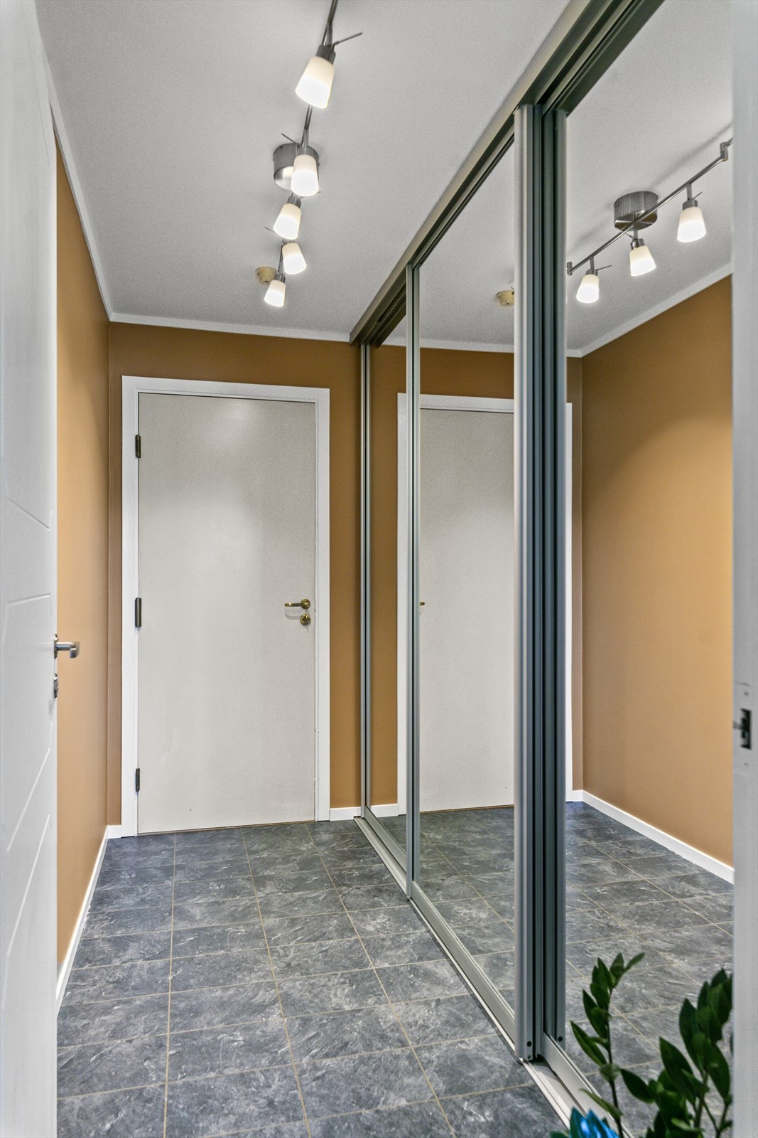 Smakfull og innbydende gang med stor skyvedørsgarderobe i speil. Galleribilde