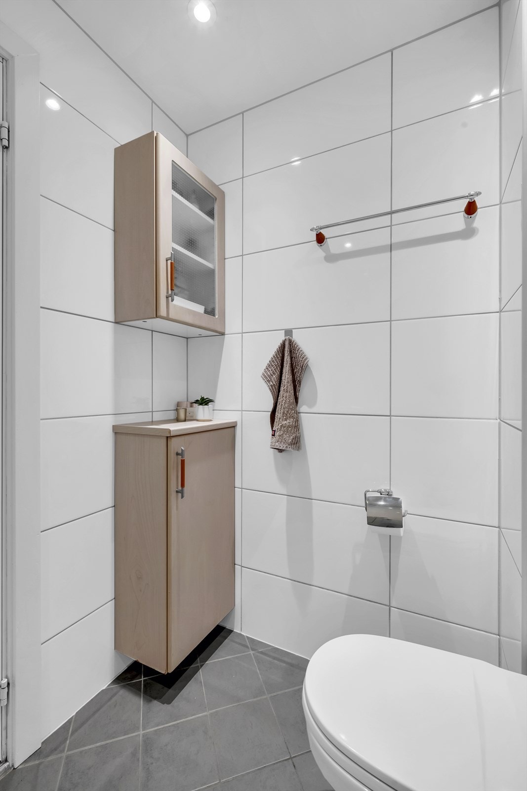 Badet har downlights i himling og er innredet med klosett, servant med speil over, og dusjhjørne med skyvedører. Det er opplegg for vaskemaskin på baderommet. Galleribilde