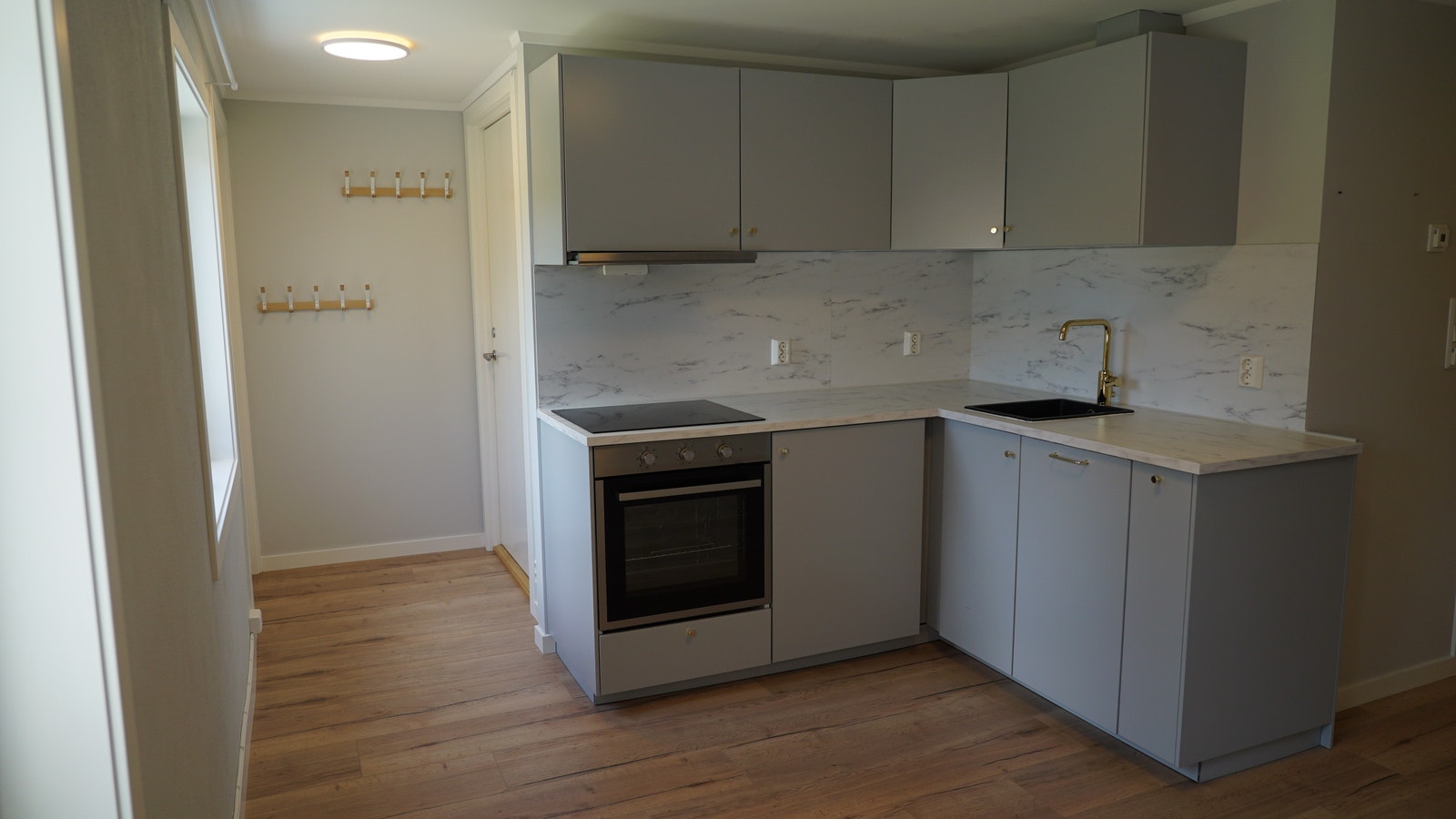 Kjøkken og inngangsparti. Nytt IKEA-kjøkken med komfyr, full platetopp, oppvaskmaskin og integrert kjøleskap med fryser under benkeplaten. Galleribilde