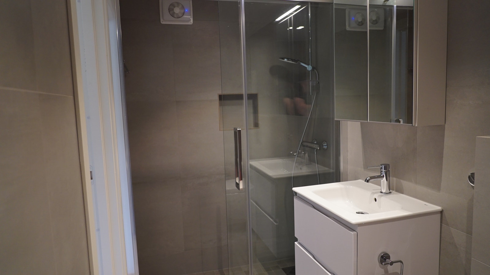 Praktisk dusjdør i glass med skyvedør. Plass til å tørke klær i dusjen. Galleribilde