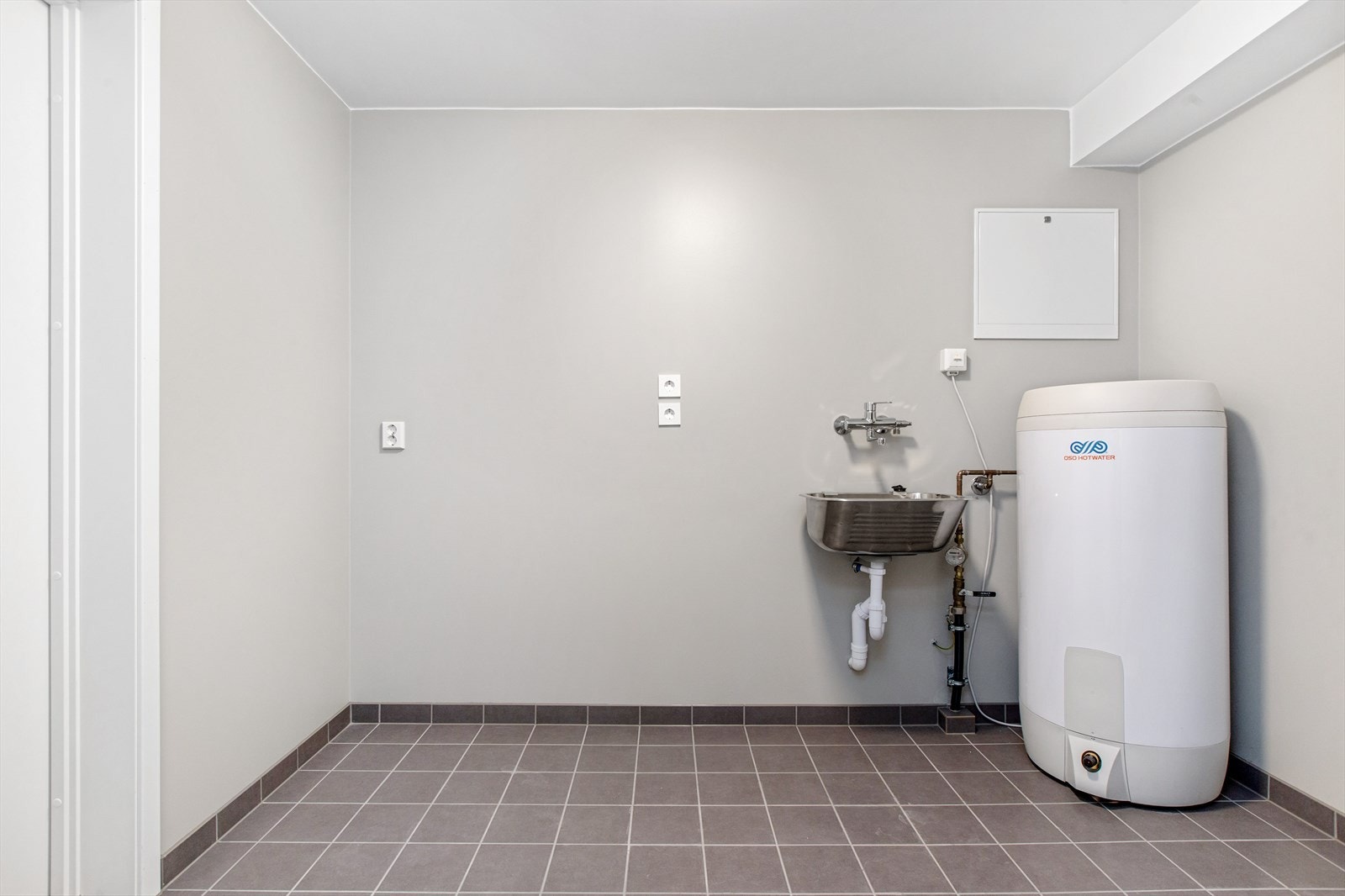 Vaskerom i boligen underetasje med direkte adkomst til integrert garasje. Rommet er innredet med utslagsvask, varmtvannstank, opplegg for vaskemaskin, ventilasjonsanlegg og sirkingsskap. Galleribilde