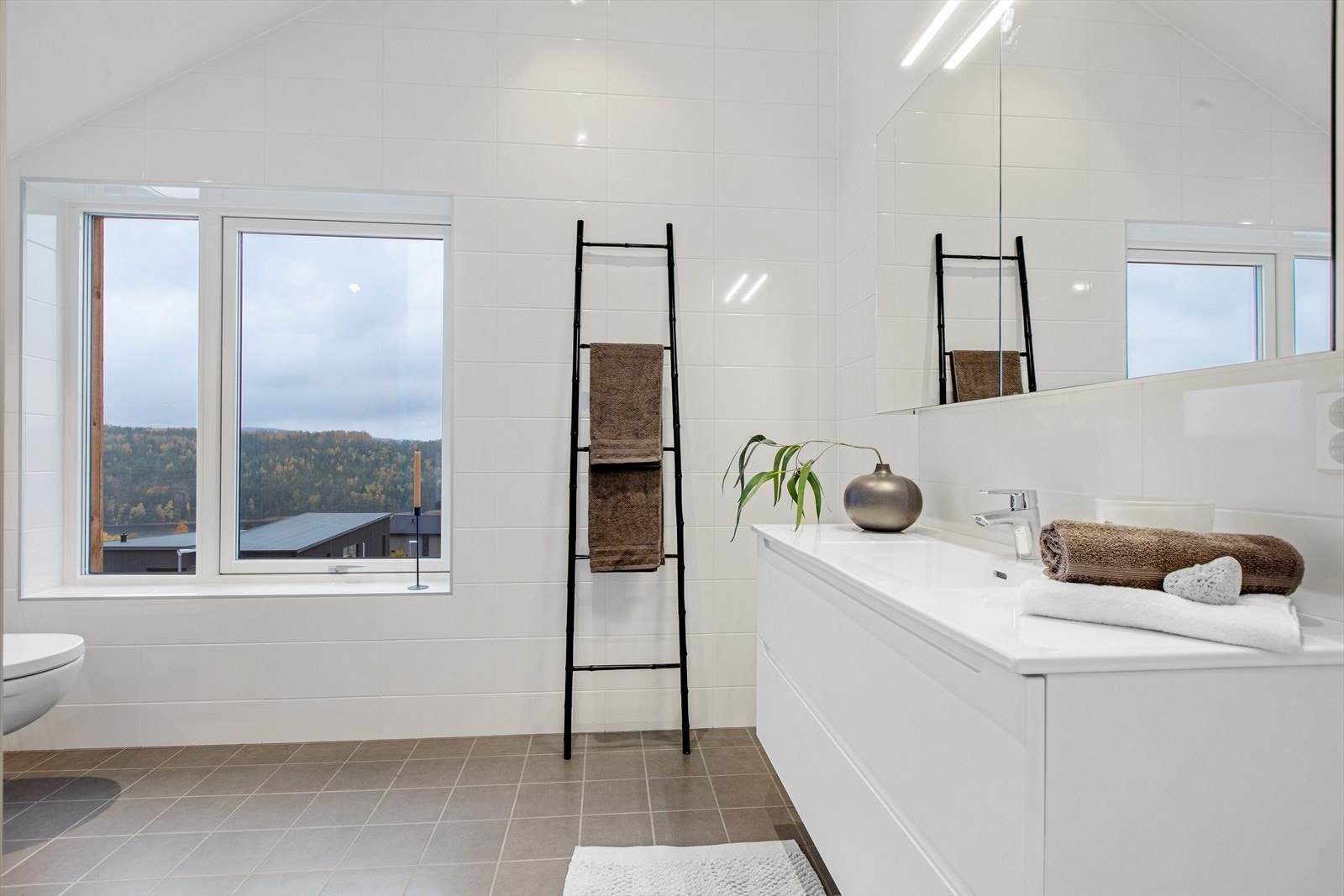 Flislagt bad med lyse overflater i boligens 2. etasje. Galleribilde