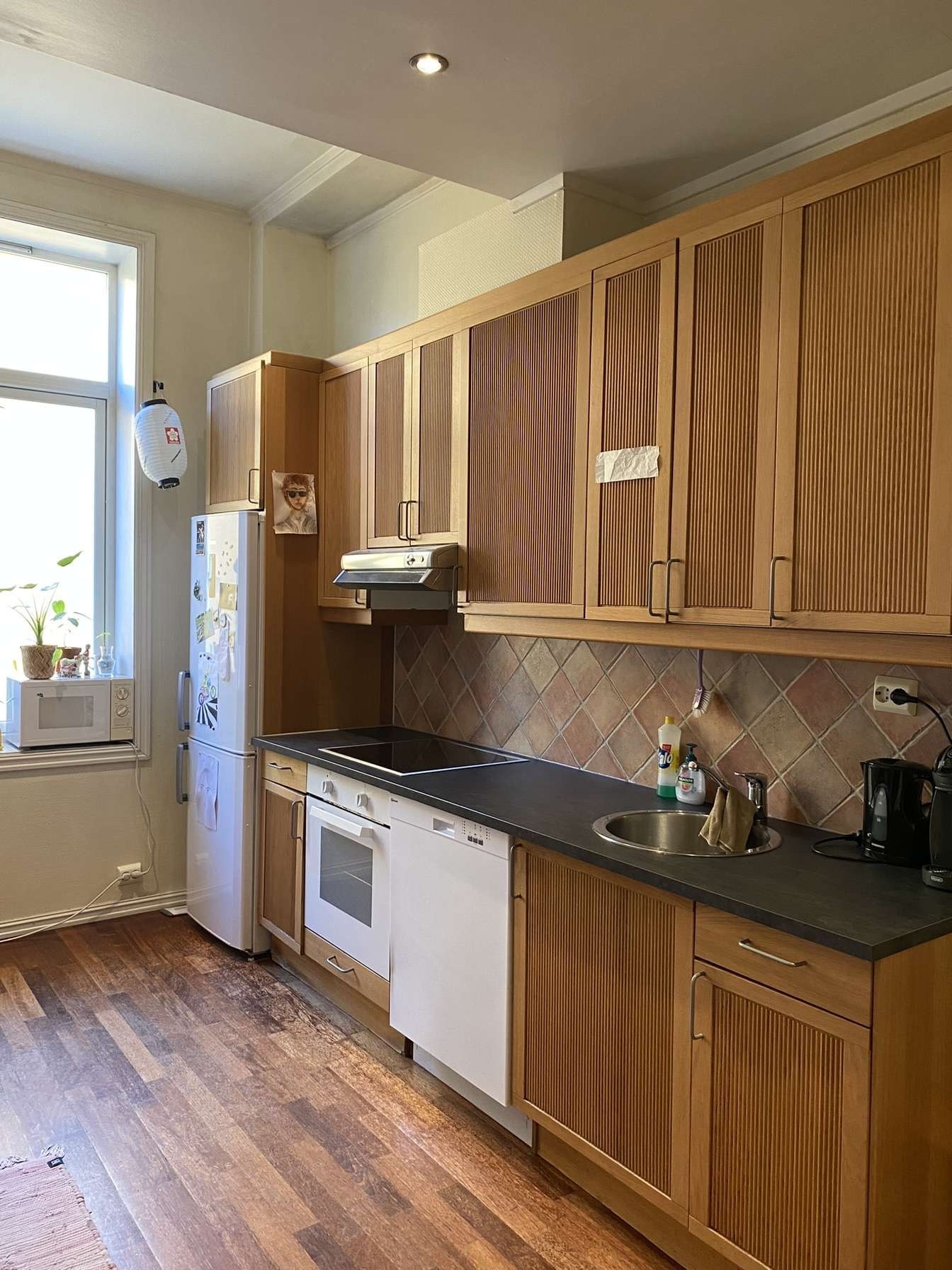 På kjøkkenet står og spisebord m. 4 stoler + sofa Galleribilde