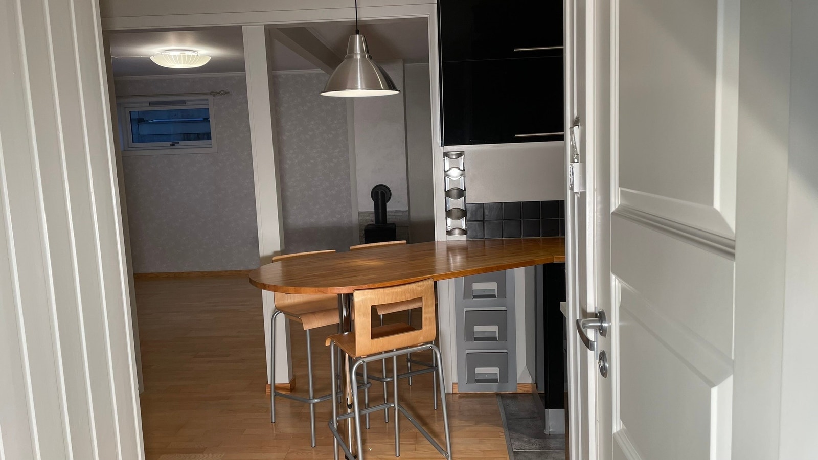 Spiseplass med 3 barkrakker, vinstativ og tidsskrifthylle. Galleribilde