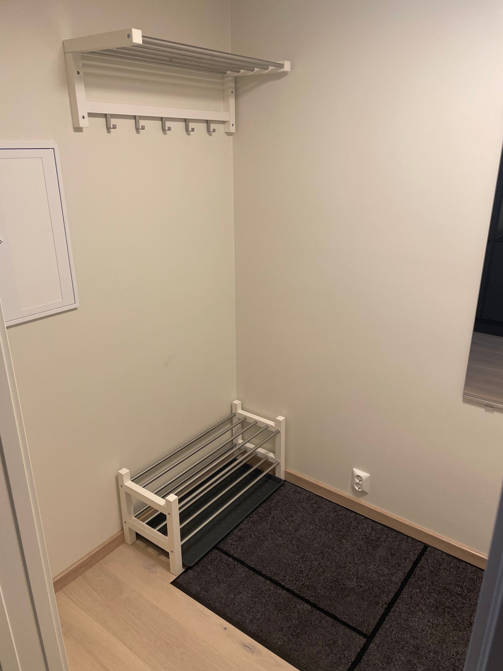 Lys og fin entre med sko og hattehyller og med veggmontert speil Galleribilde