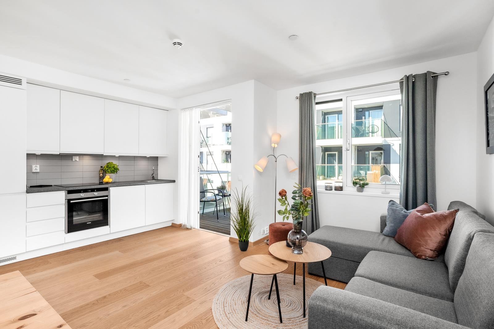 Åpen stue-og kjøkkenløsning med masse lys fra vinduene i nordvest. Galleribilde