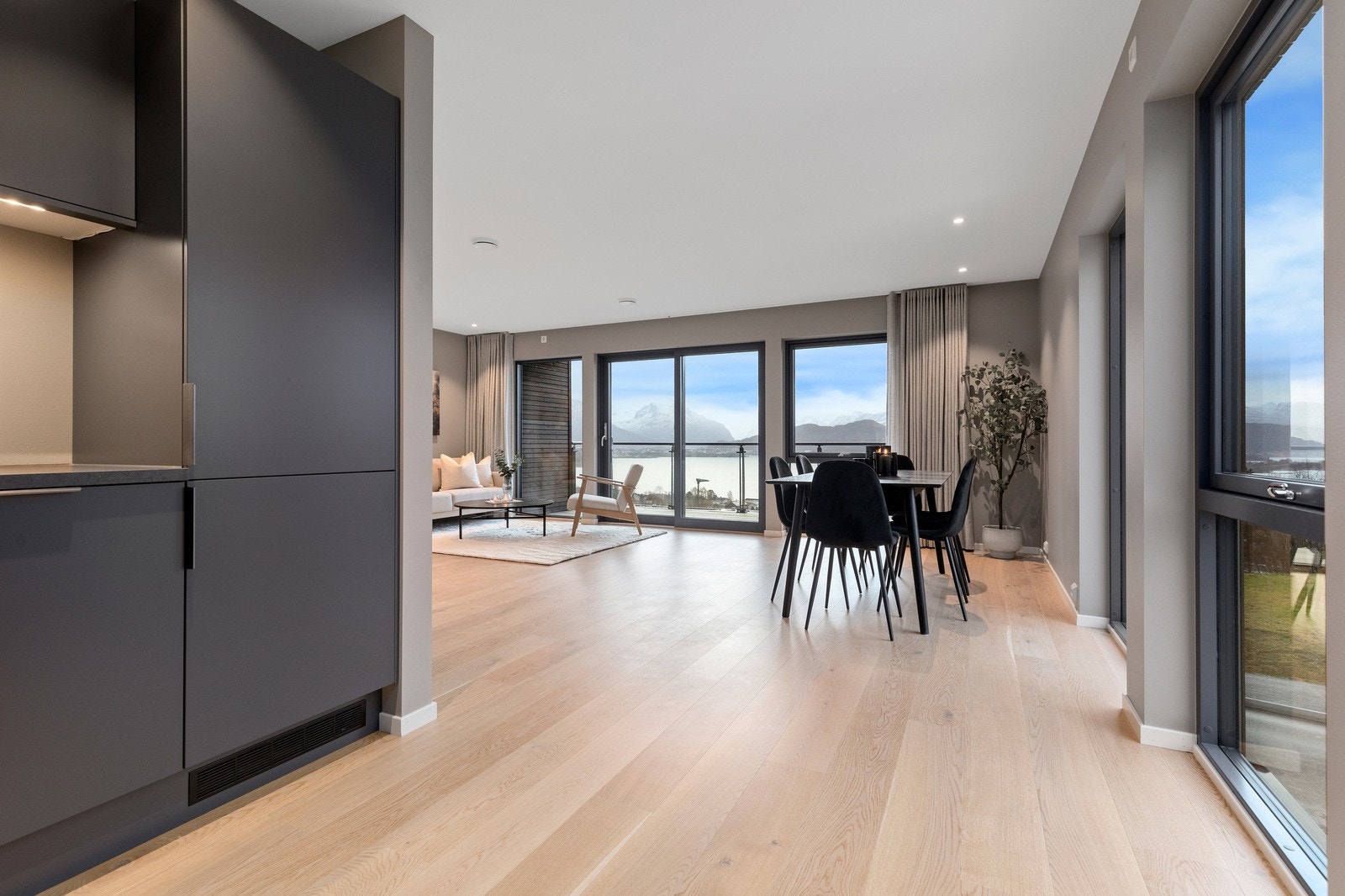 Fra kjøkken mot spisestue og stue med fantastisk utsikt mot Åsefjorden og Sunnmørsalpane. Galleribilde