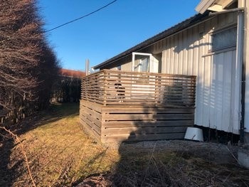 Usjenert veranda med kveldssol, samt en liten hageflekk. Galleribilde