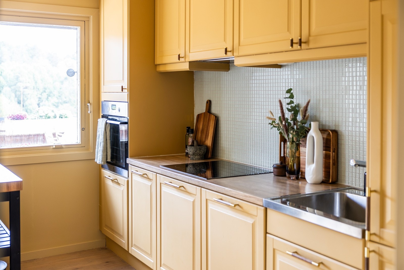 Integrerte hvitevarer og flisfelt over benkeplaten. Galleribilde