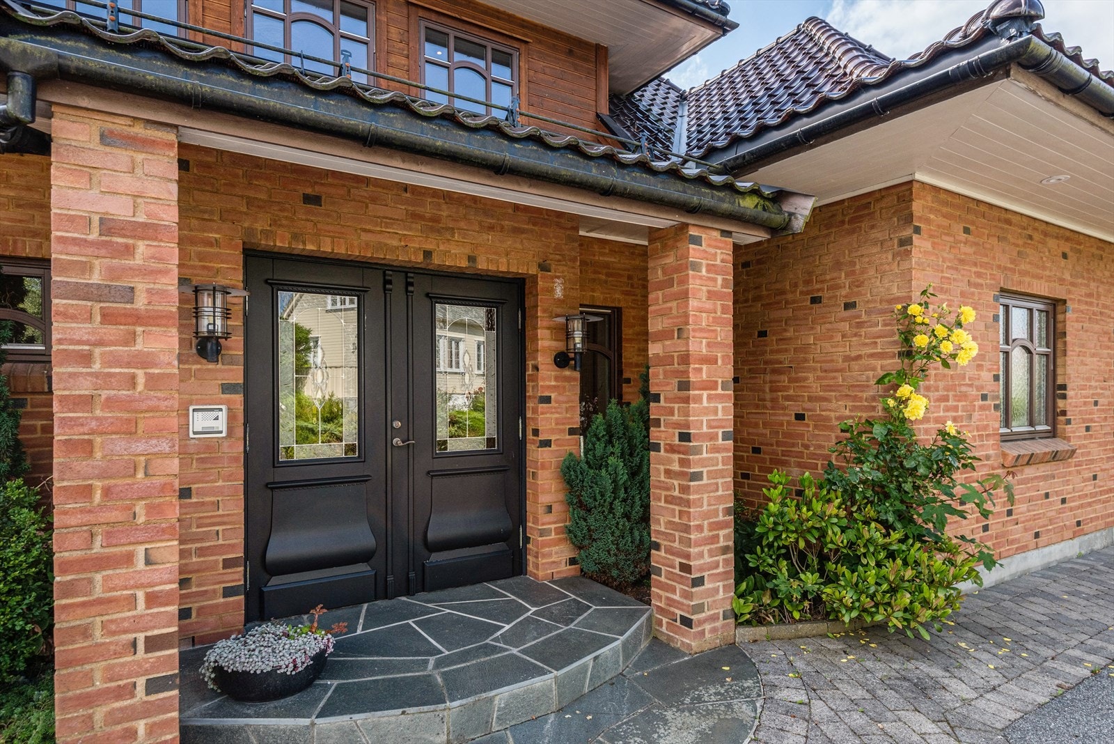 Flott, overbygget inngangsparti med tofløyet ytterdør og utebelysning. Galleribilde